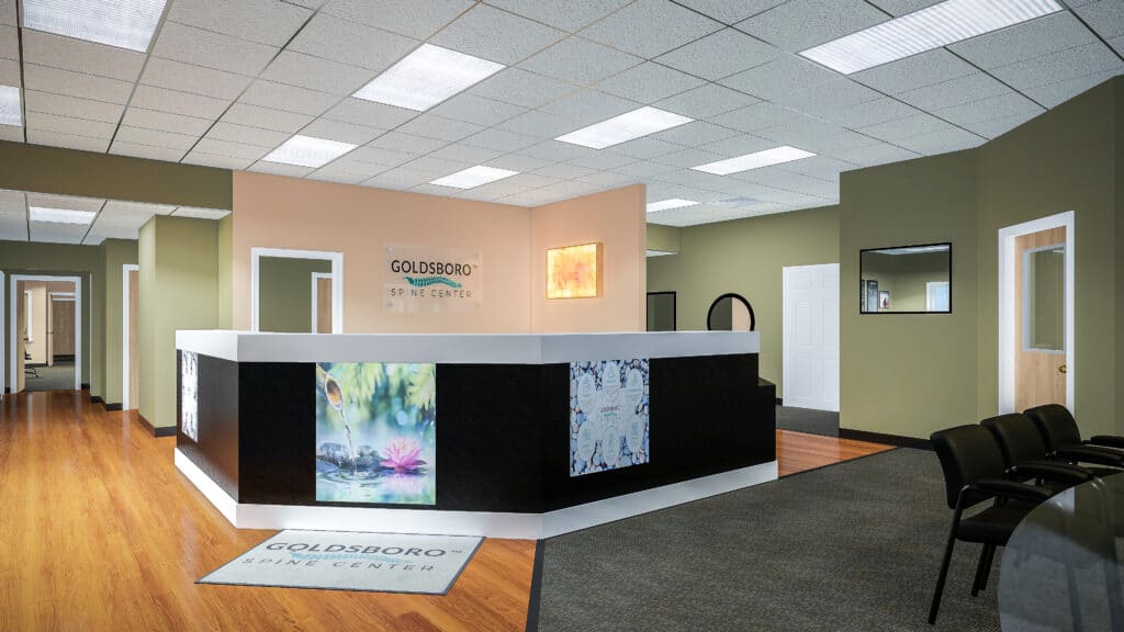 Reception area at Goldsboro Spine Center in Goldsboro, NC, showing the front desk, waiting area, clinic signage, and chiropractic office environment.