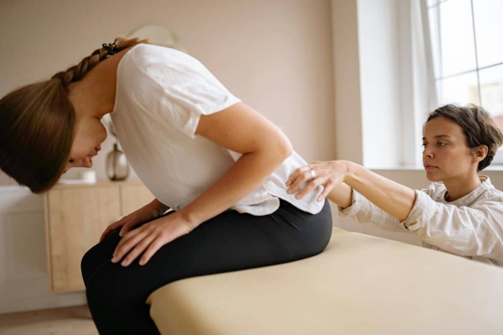 Chiropractic provider assessing a patient’s low back movement during a spinal health evaluation in Goldsboro, NC.