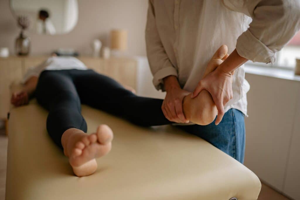 Chiropractic provider assessing a patient’s foot and ankle mobility during a lower extremity and spinal health evaluation in Goldsboro, NC.